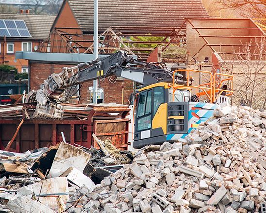 a pile of bricks is being demolished by a bulldozer .