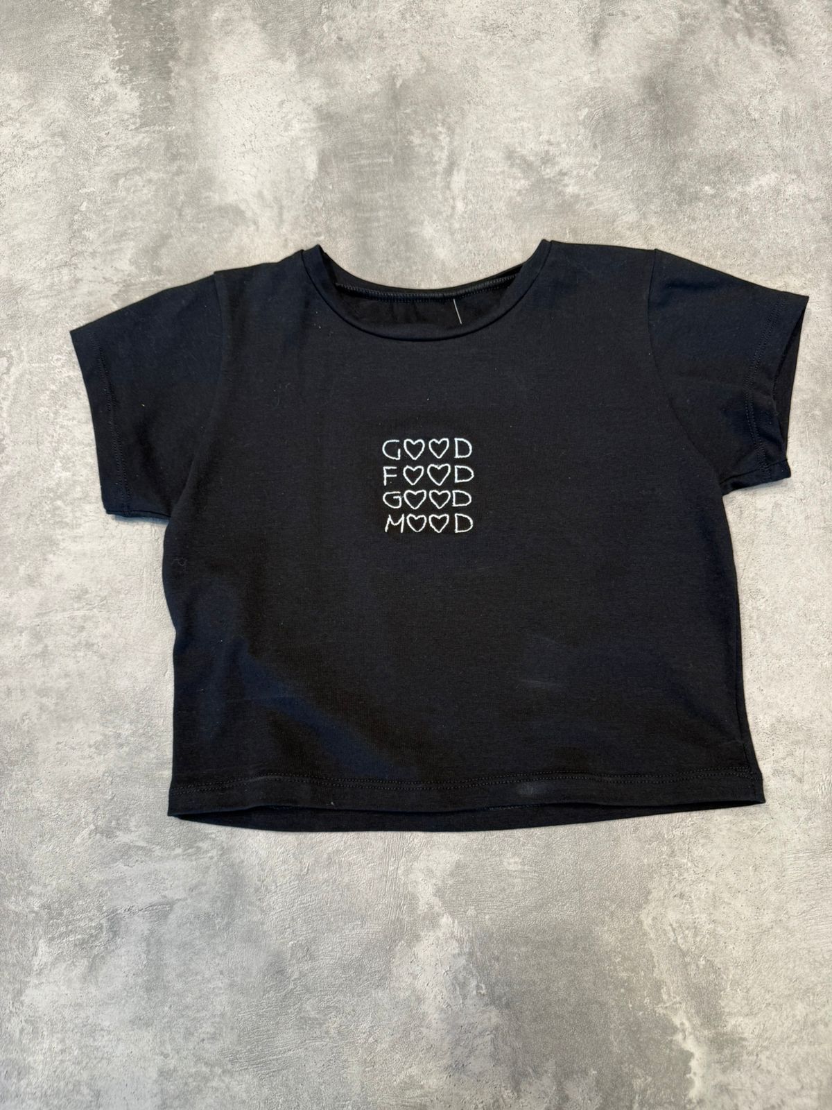 Top corto negro con las palabras 