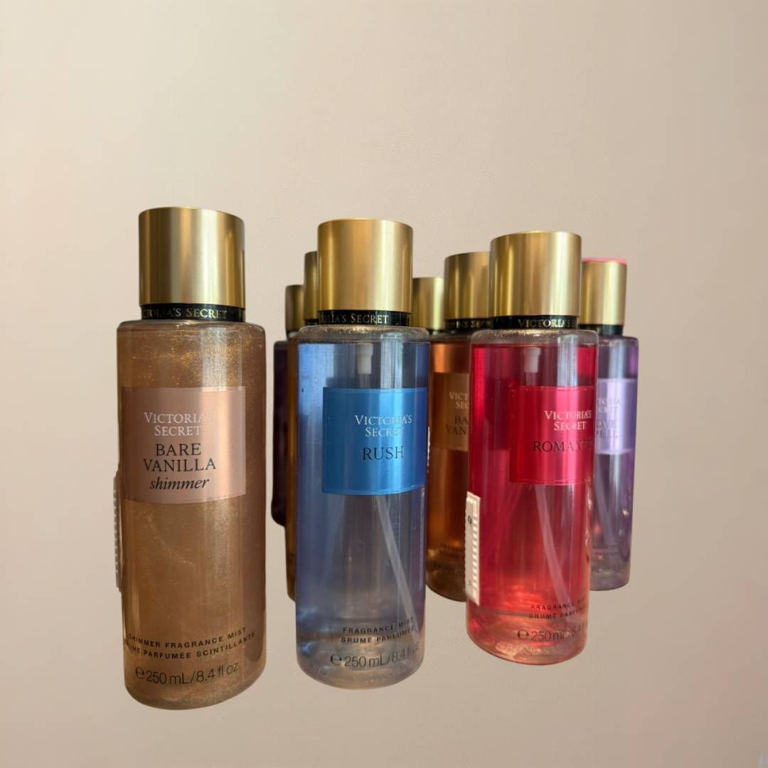 Varios sprays corporales de Victoria's Secret en varios colores con tapones dorados.