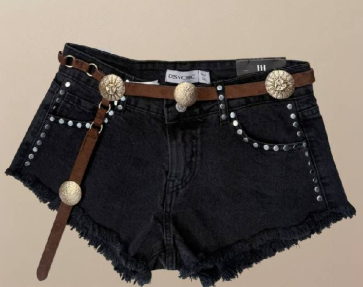 Shorts vaqueros negros con bordes deshilachados y cinturón con tachuelas.