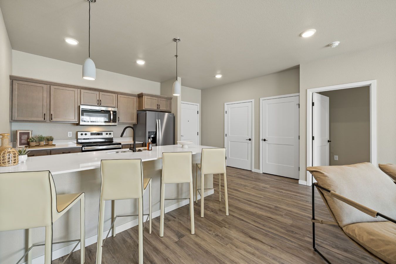 a kitchen with a bar and stools in a living room .