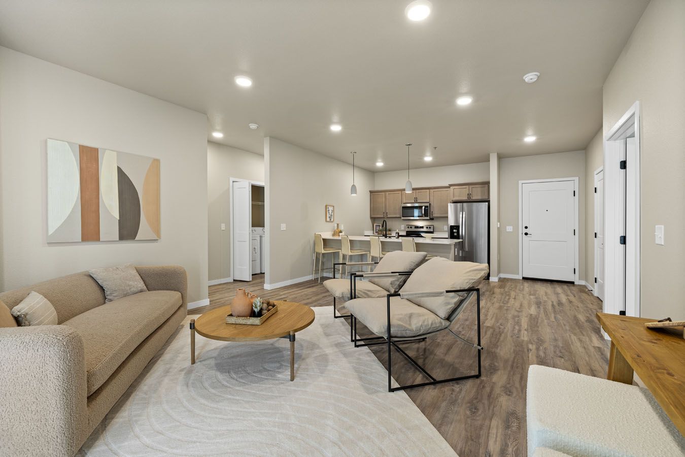 a living room with a couch , chair , coffee table and kitchen .