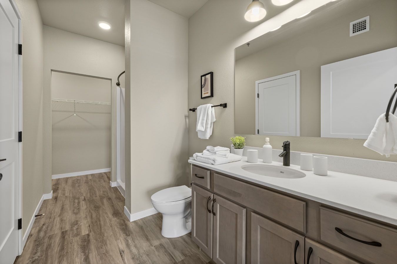 a bathroom with a toilet , sink , mirror and walk in shower .