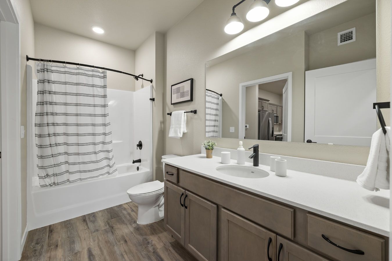 a bathroom with a sink , toilet , bathtub and mirror .