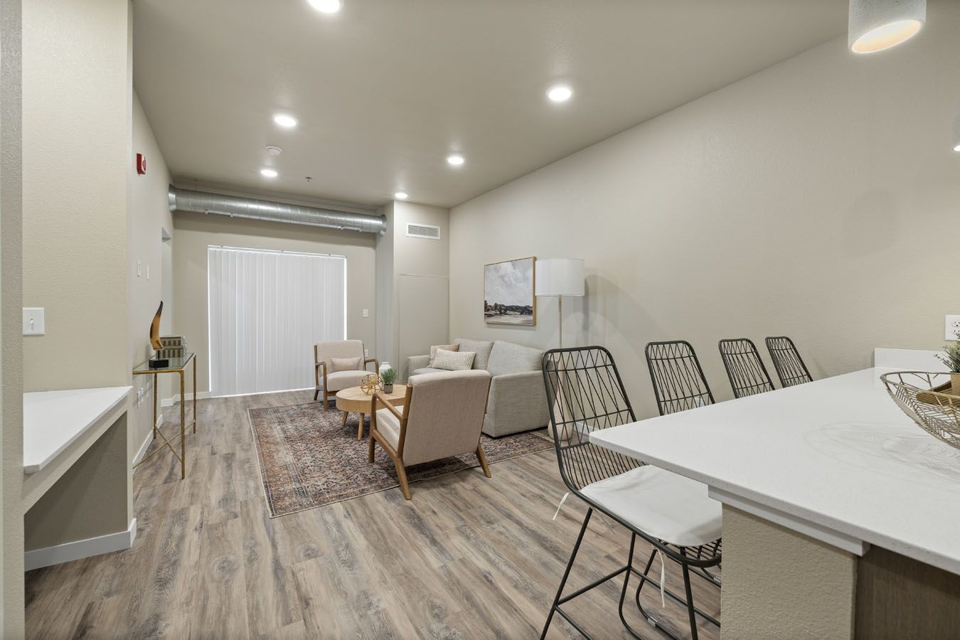 a living room with hardwood floors , a couch , chairs and a table .