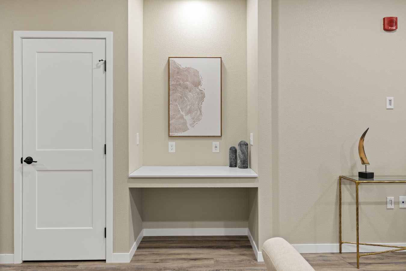a living room with a desk and a painting on the wall .