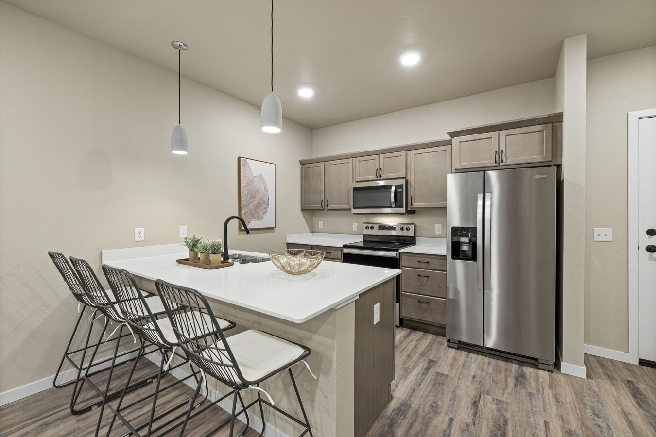 a kitchen with stainless steel appliances and a large island with stools .