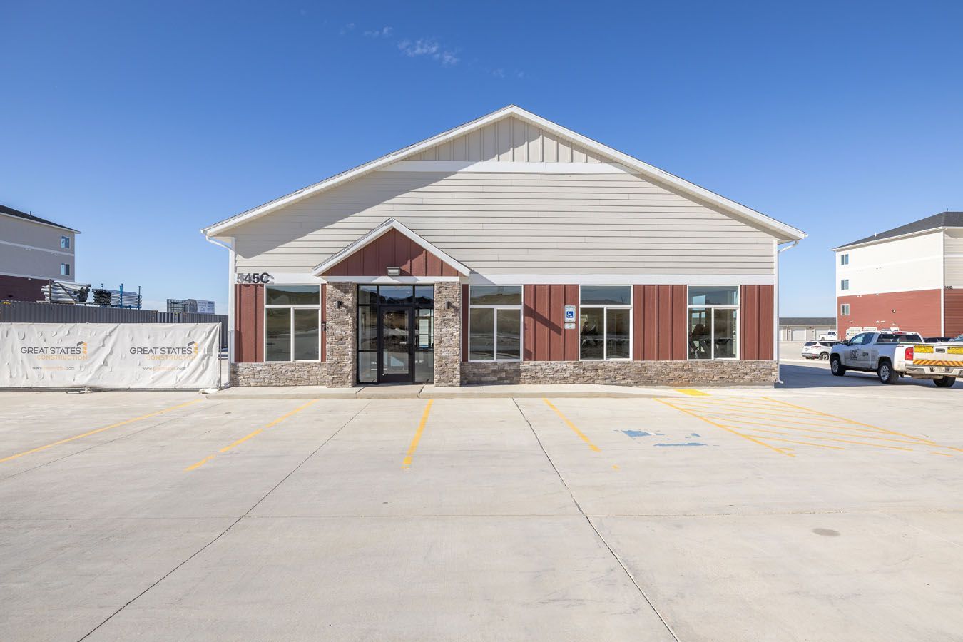 a large building with a lot of windows and a parking lot in front of it .