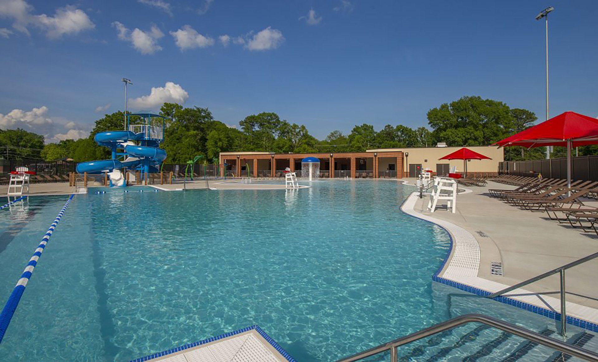 A large swimming pool with a water slide in the background.