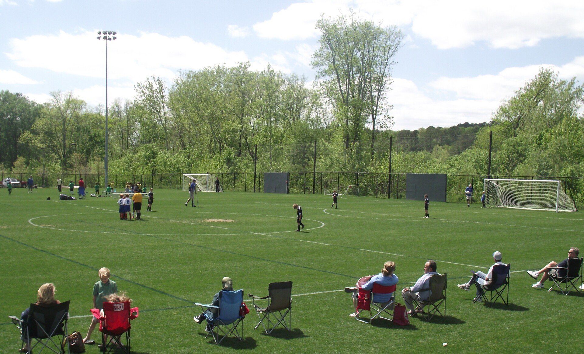A group of people sit in chairs on a soccer field