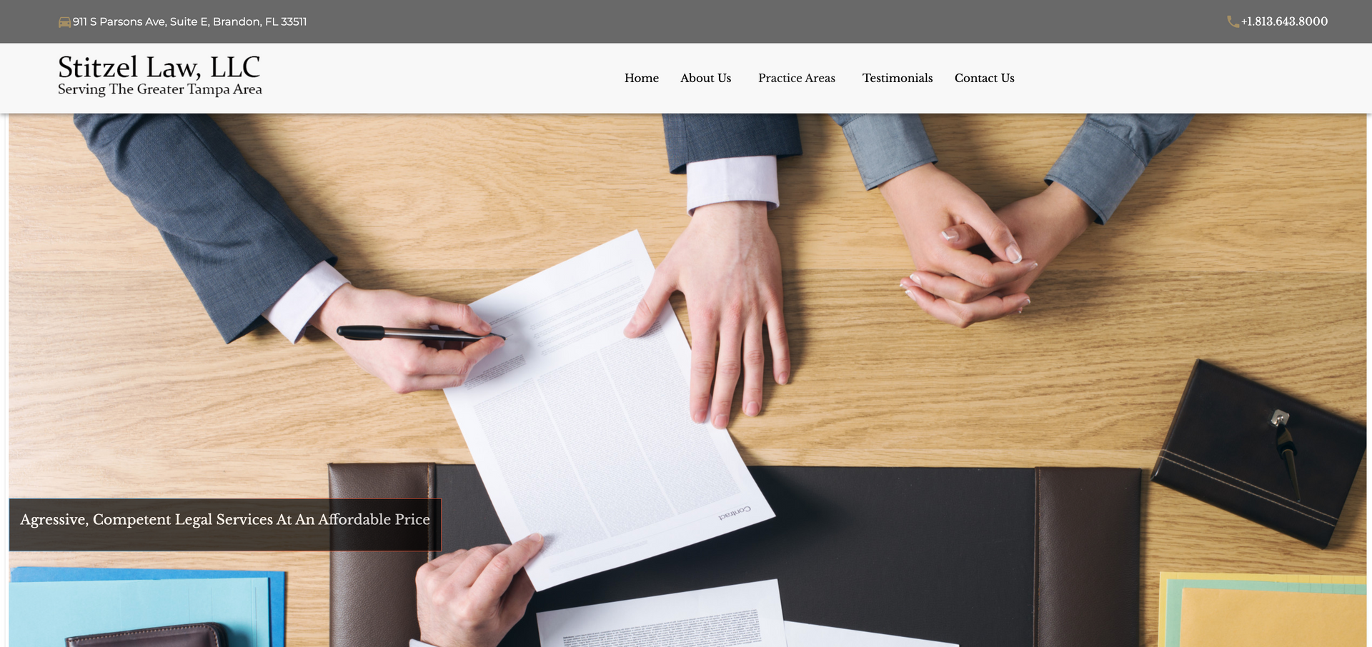a group of people are sitting at a table signing a document .