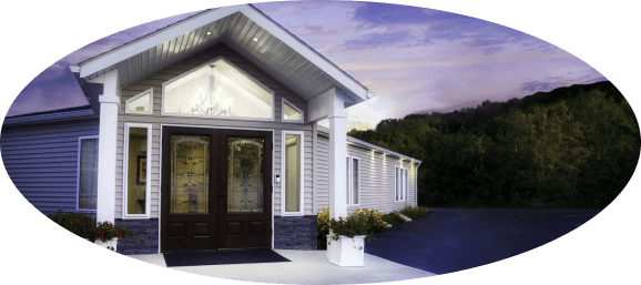 Small house entrance with double doors, white trim, and a porch at dusk, framed in an oval vignette.