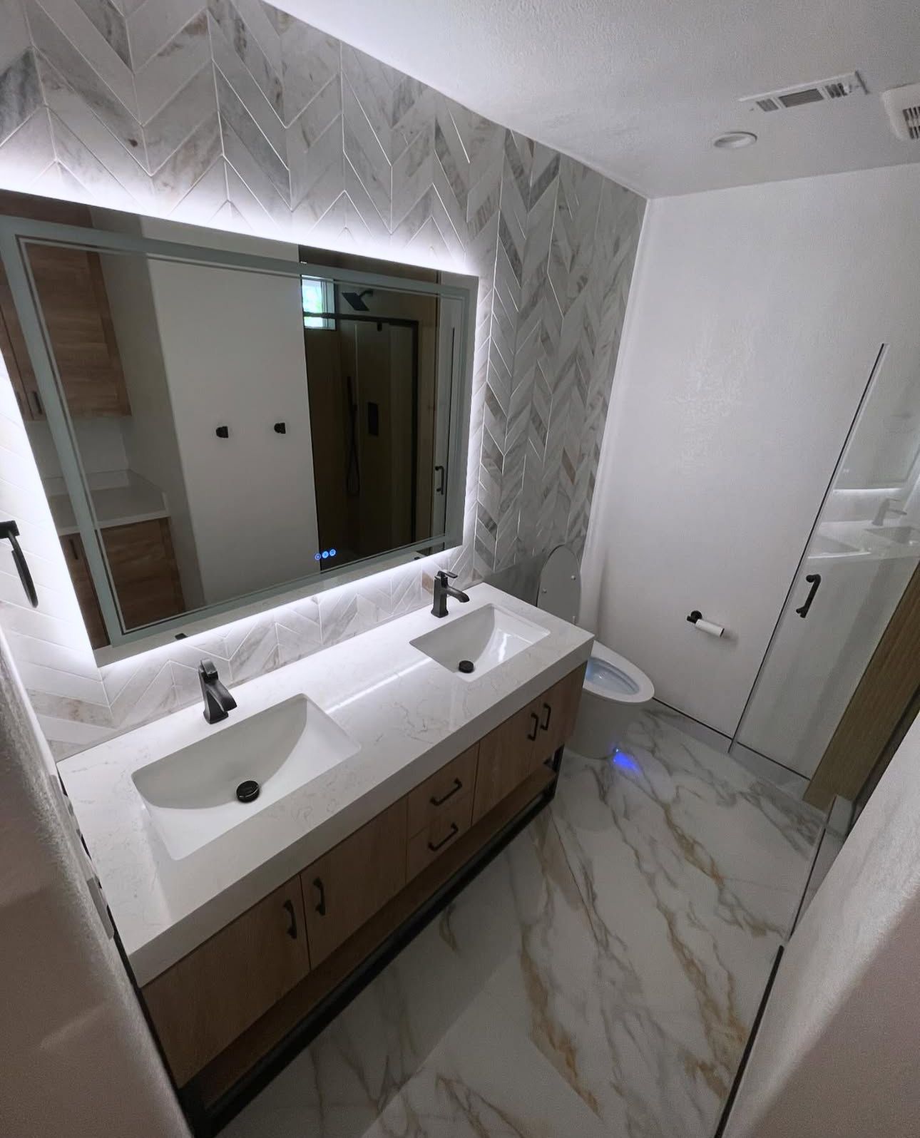 A bathroom with two sinks and a large mirror