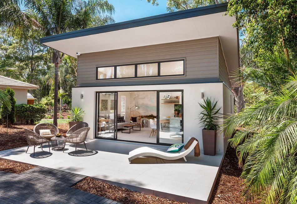 A small Accessory Dwelling Unit (ADU) with a patio and chairs in front of it