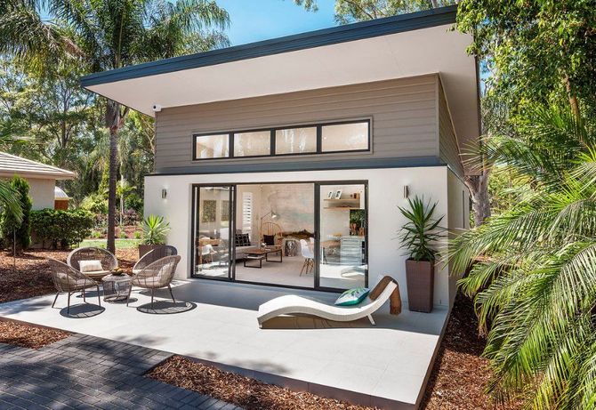 A small house with a patio and chairs in front of it