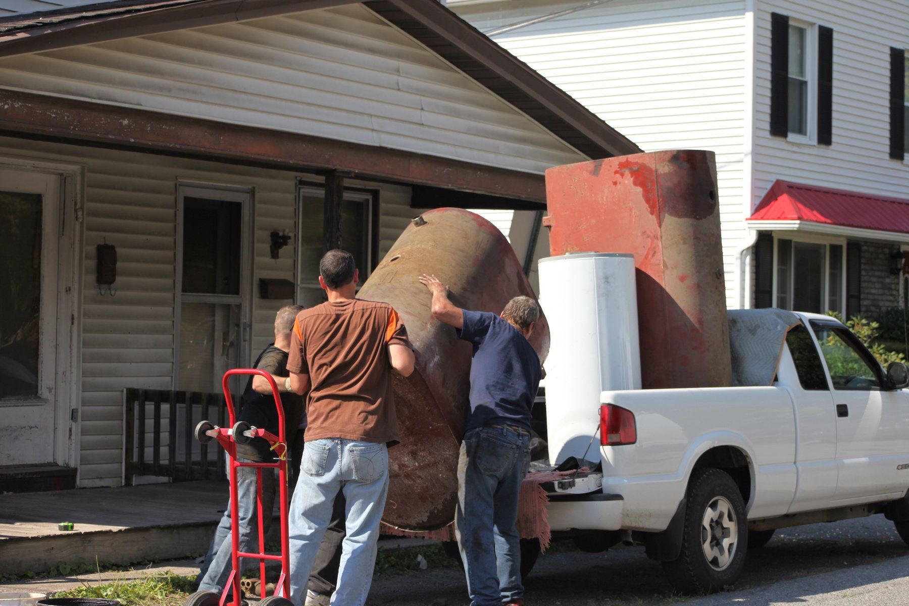 Two men loading a truck with various scrap materials destined for the recycling yard.