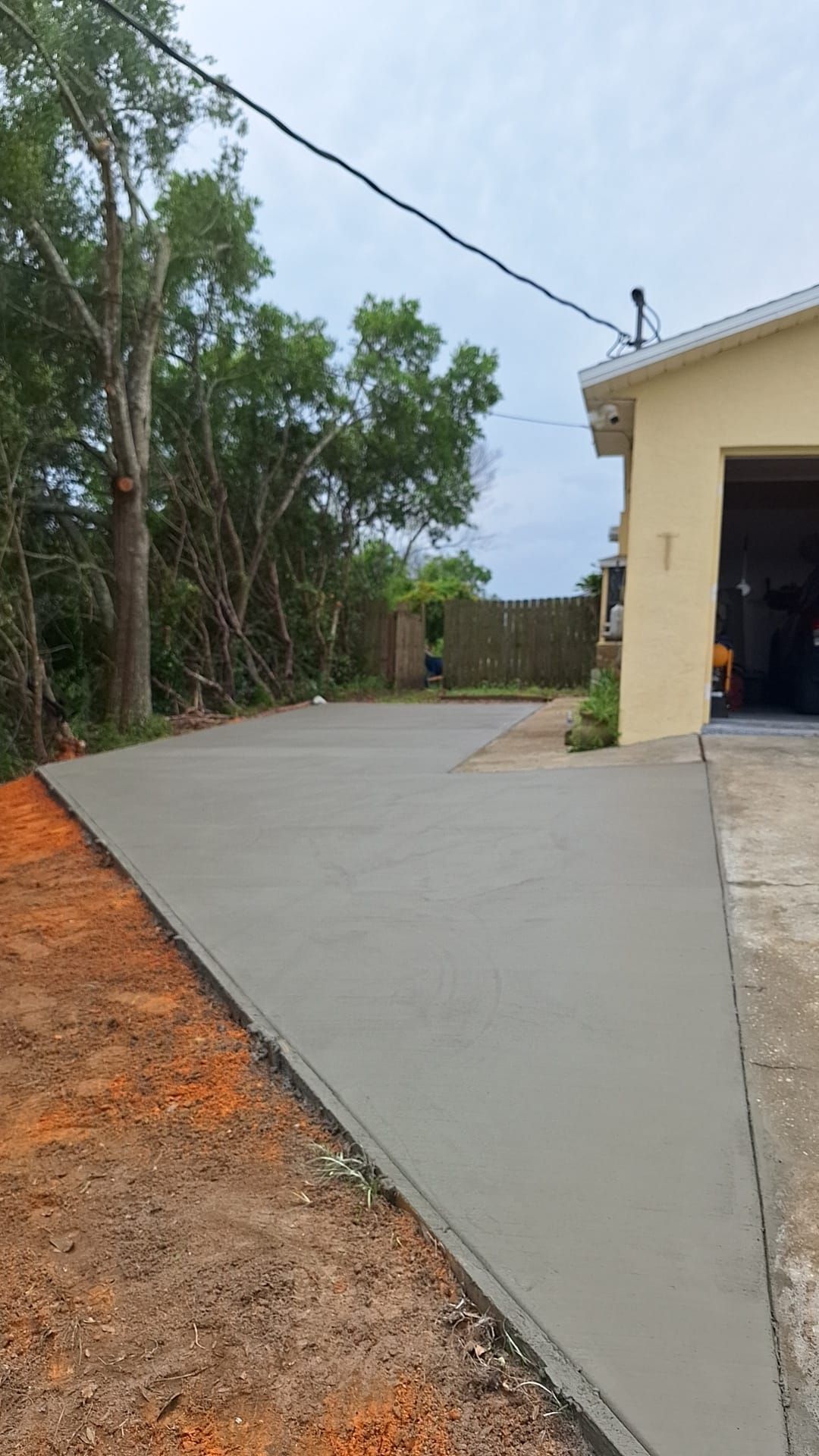 A concrete driveway is being built in front of a house.