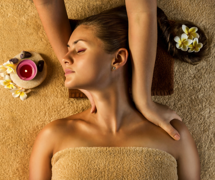 A woman wrapped in a towel is getting a massage at a spa