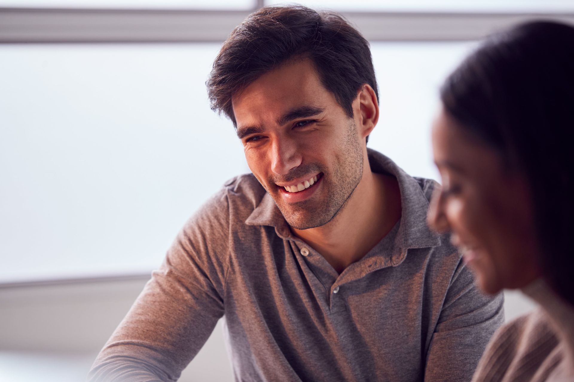 A woman is sitting on a couch with her legs crossed.
