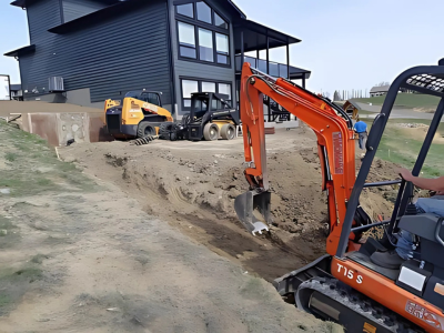 A small orange excavator is digging a hole in front of a house.