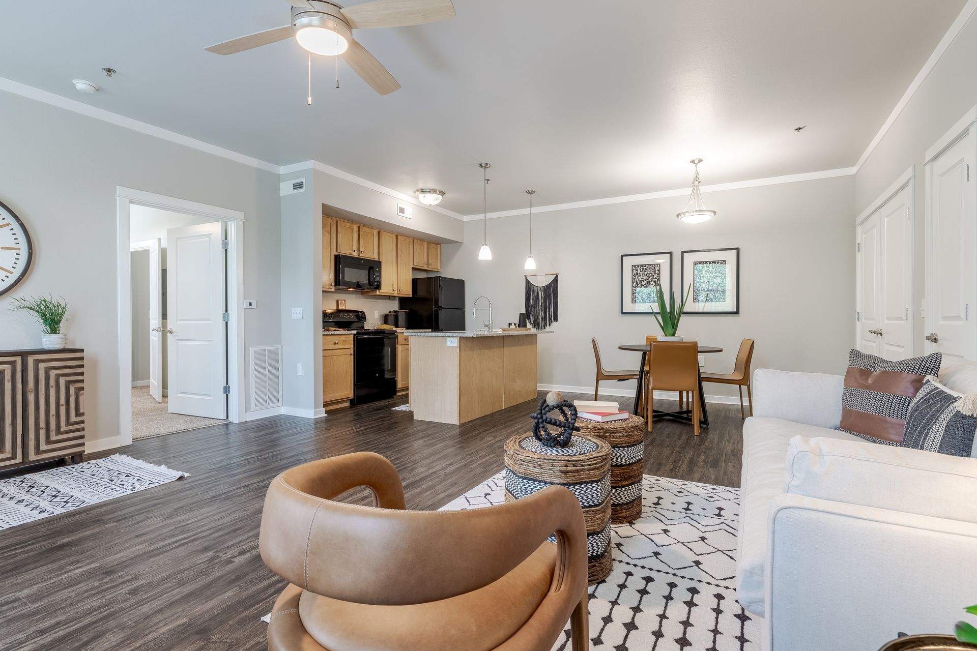 A kitchen with wooden cabinets , black appliances , granite counter tops and a sink.