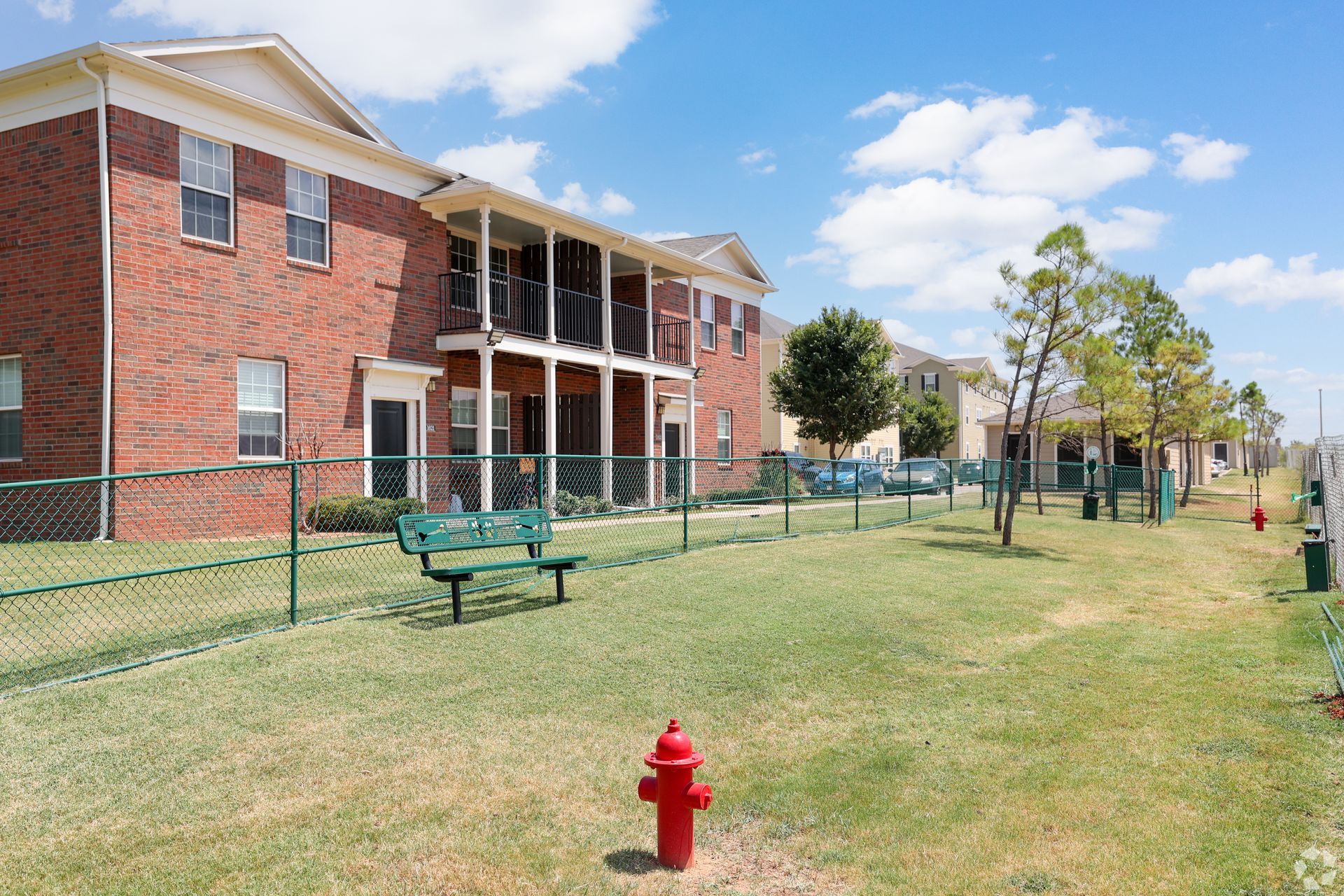 A large lawn in front of a row of apartment buildings.