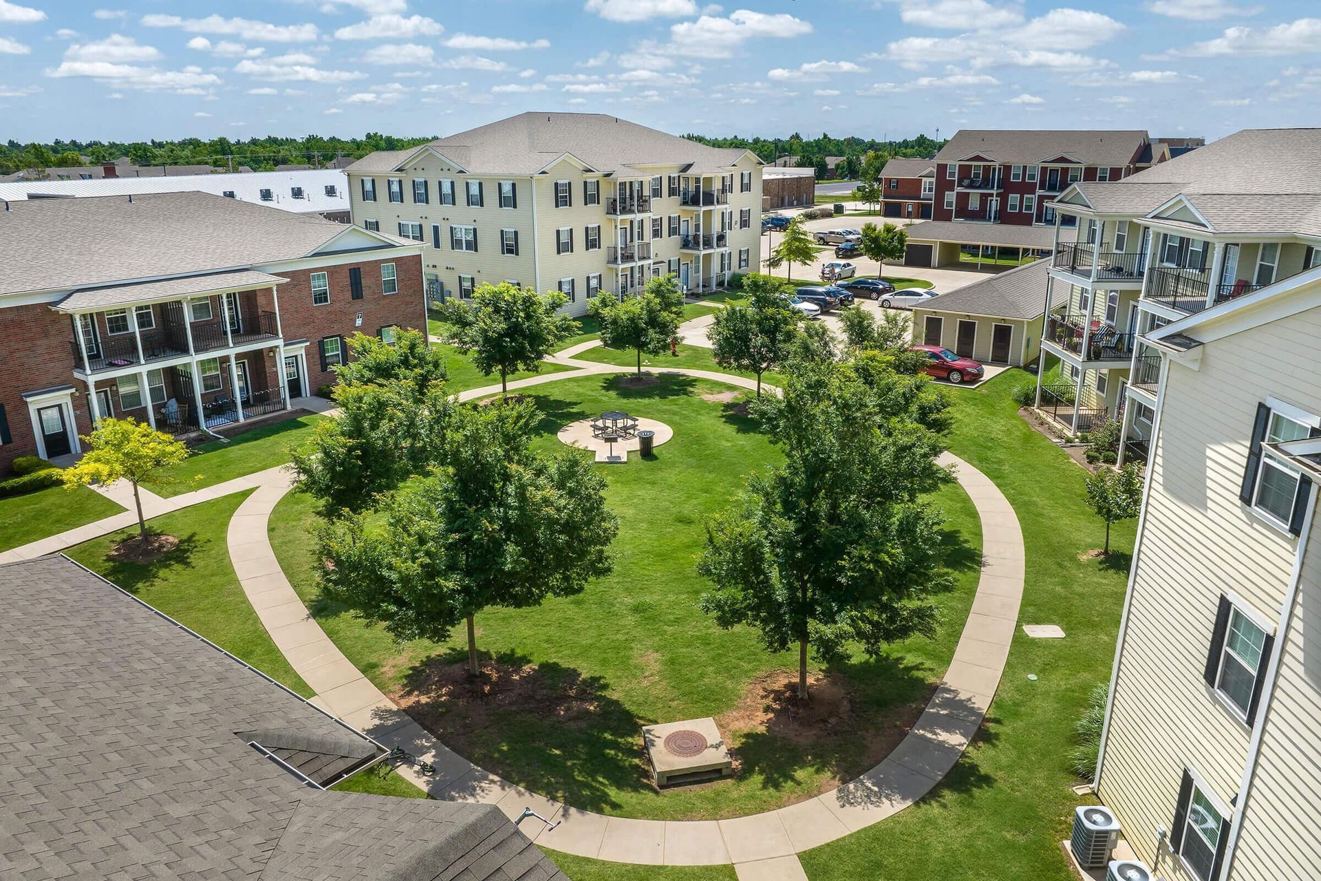 Aerial view of apartment complex with green courtyard and walkways.