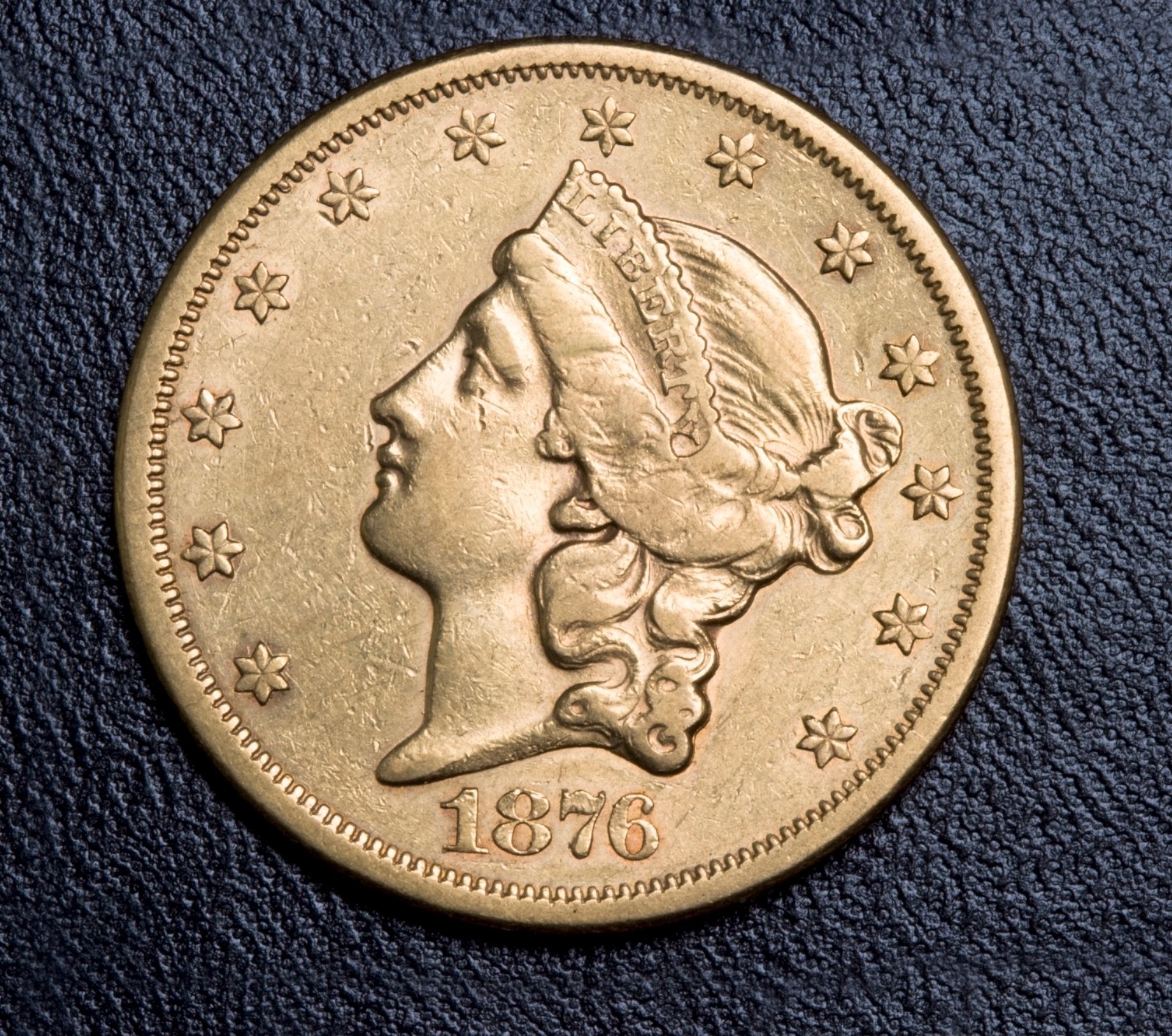 Gold 1876 Liberty Head coin with profile of Liberty, stars around the rim, and the date.