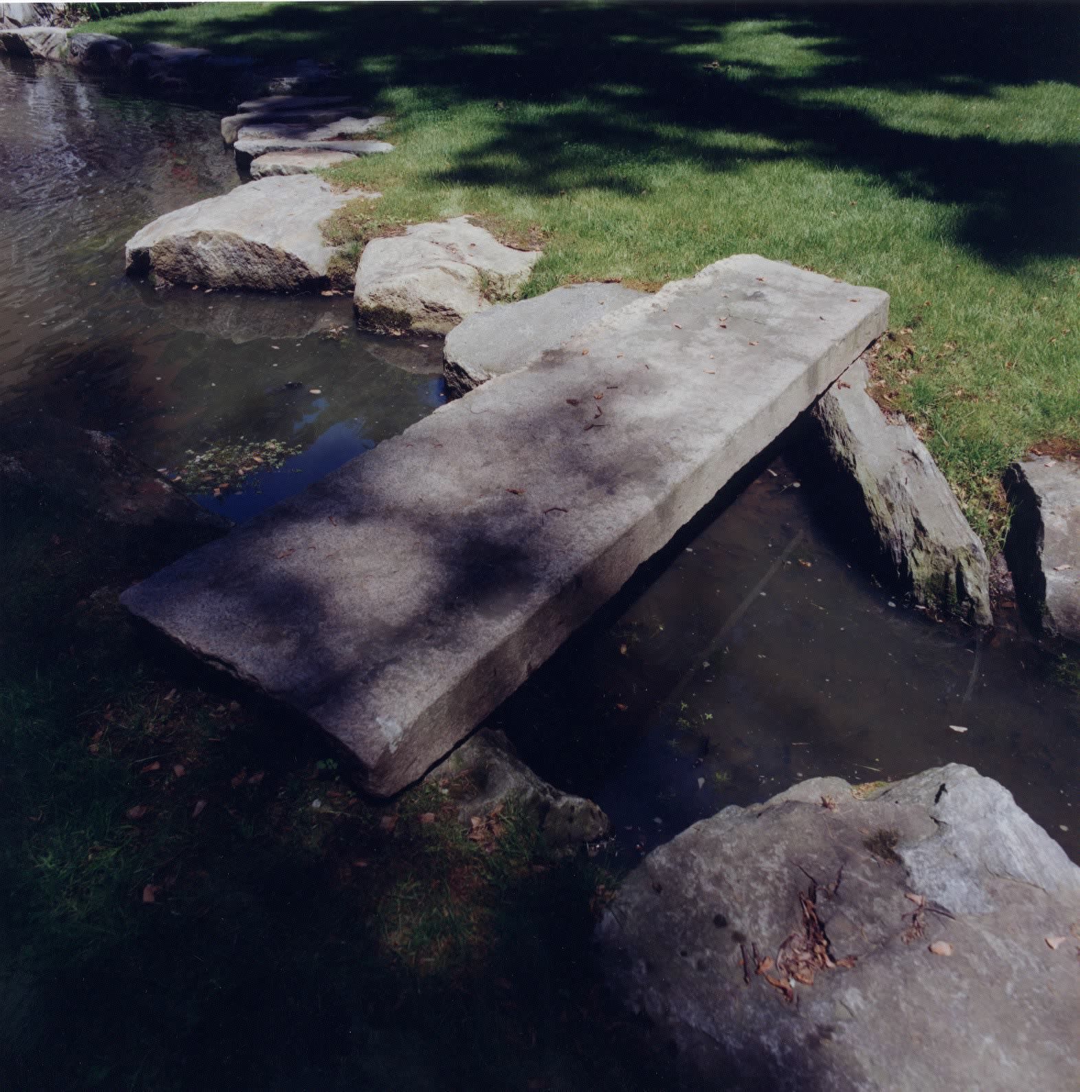 A stone bridge over a stream in a park