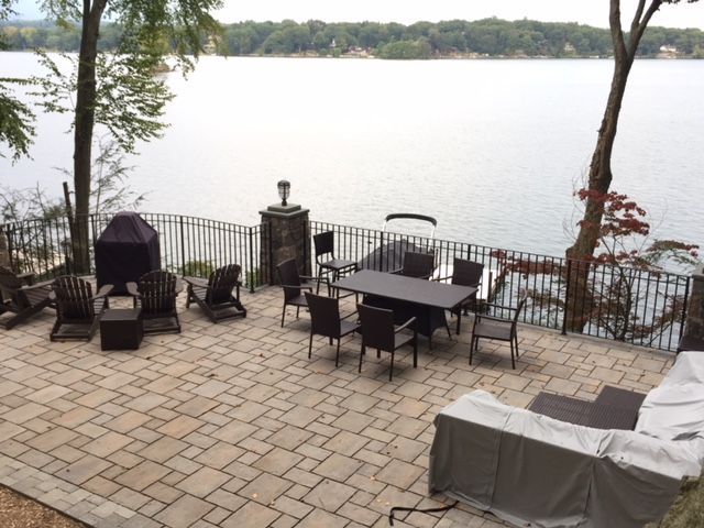 A patio with a table and chairs overlooking a lake