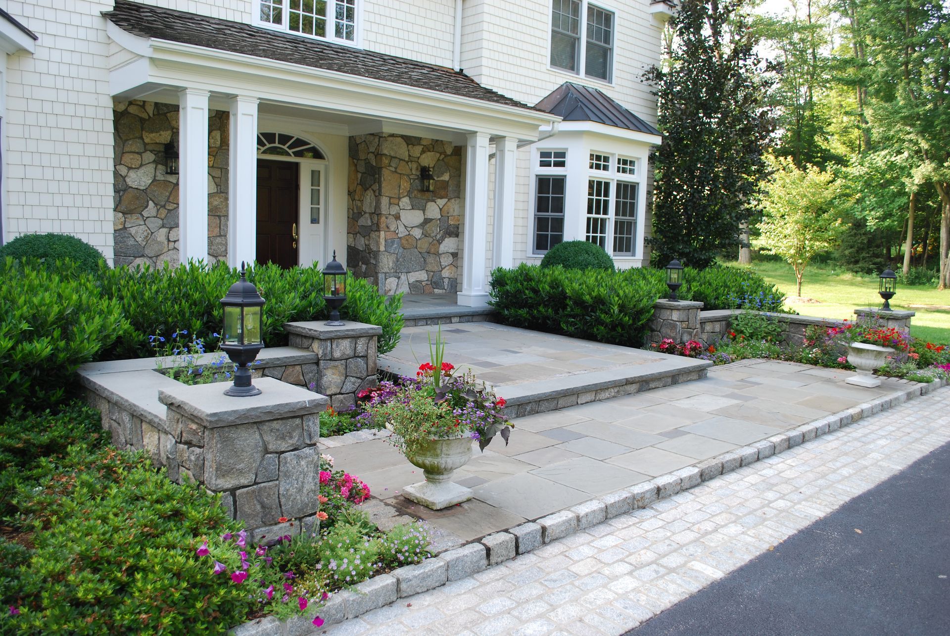 A large white house with a stone porch and steps