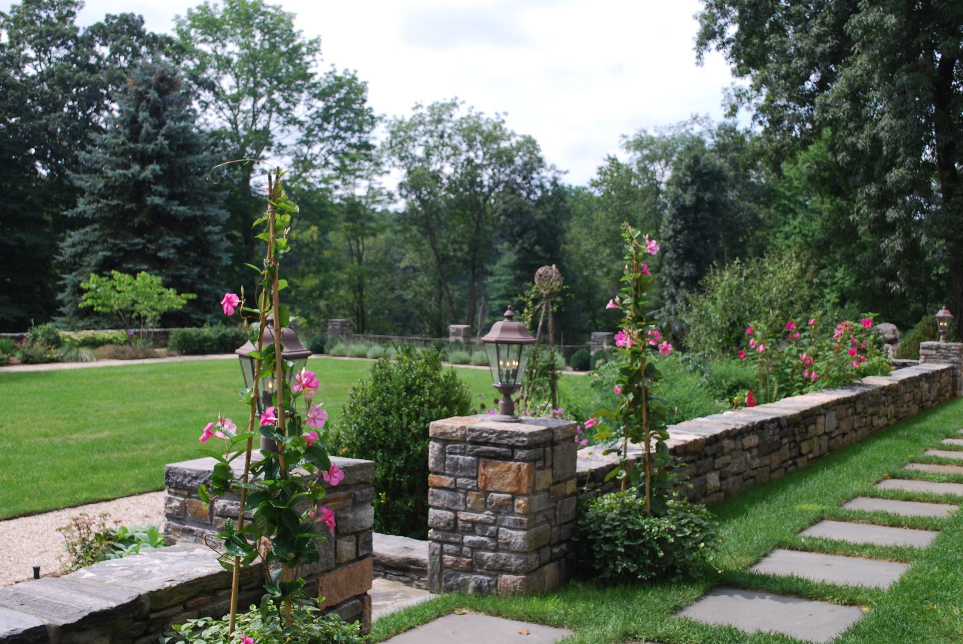 A stone walkway leading to a lush green field