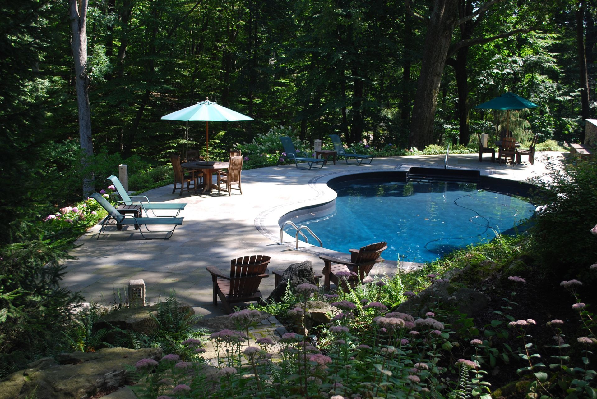 A large swimming pool surrounded by chairs and umbrellas