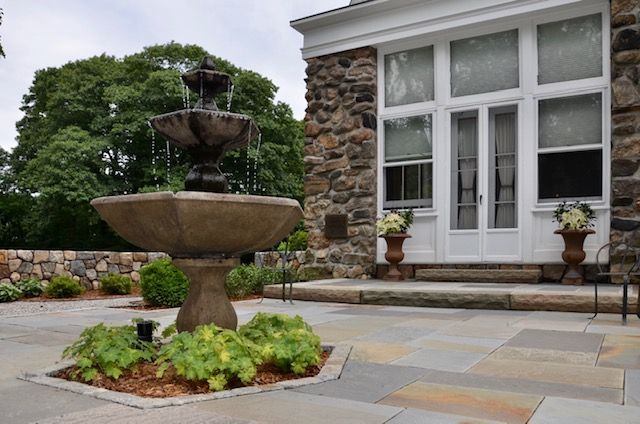 A fountain is in front of a stone building