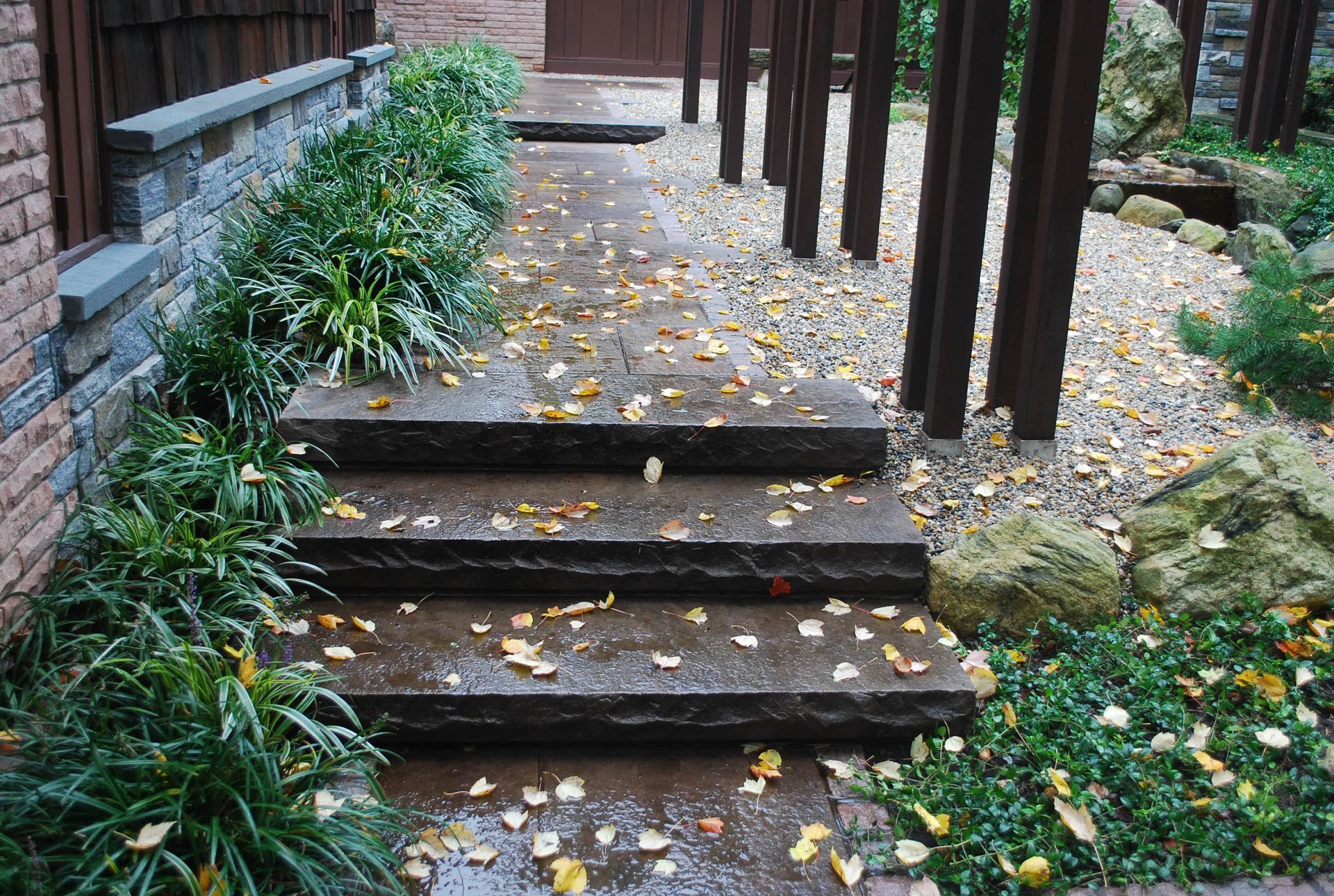 A set of stairs leading up to a house with leaves on the ground