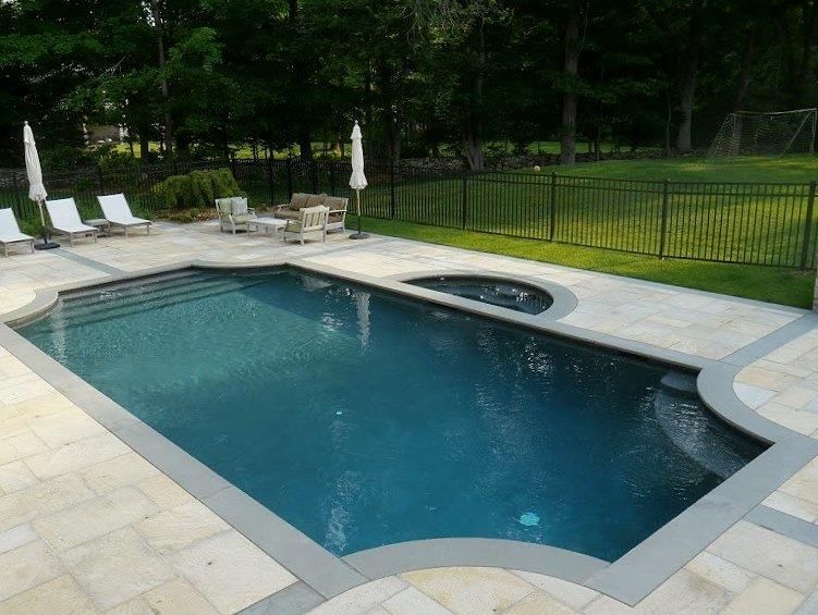 A large swimming pool with chairs and umbrellas around it