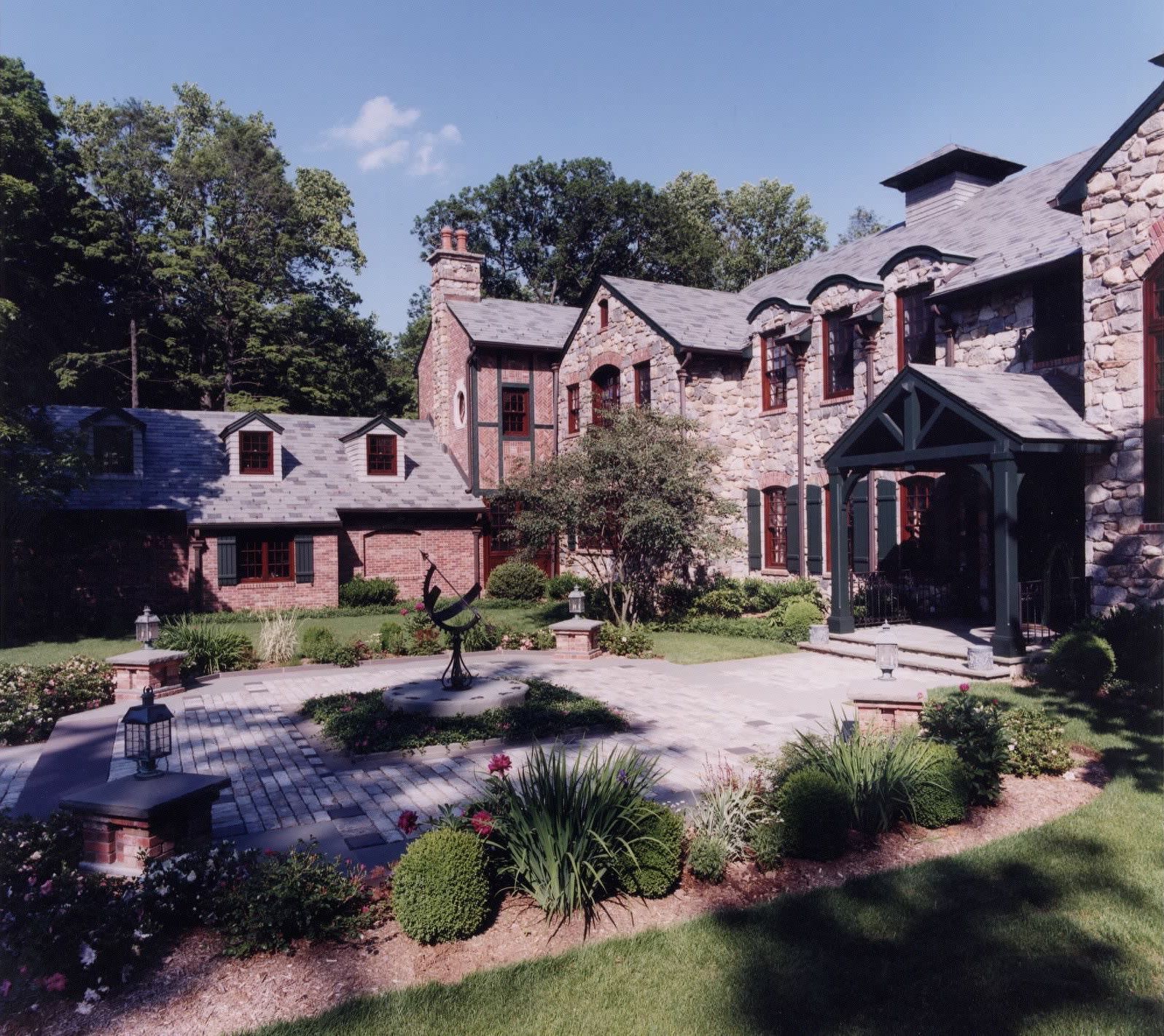 A large brick house with a patio in front of it