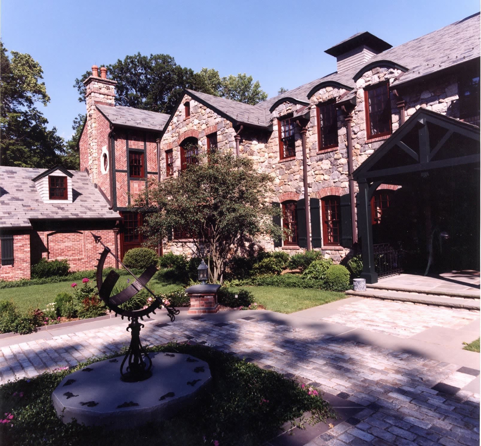 A large brick house with a fountain in front of it