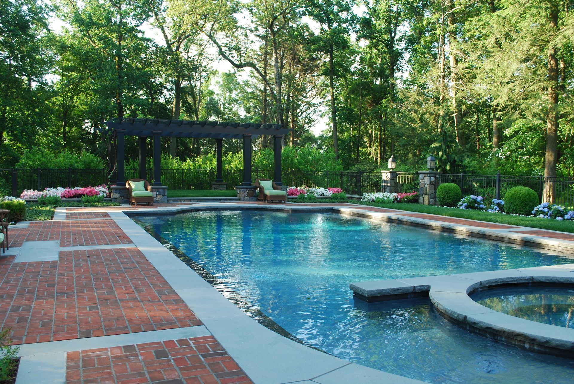 A large swimming pool with a pergola in the background