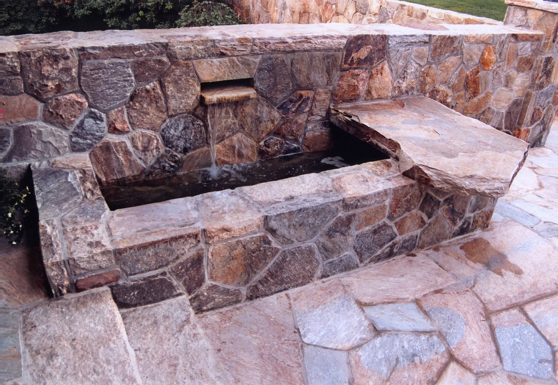 A stone wall with a waterfall in the middle of it