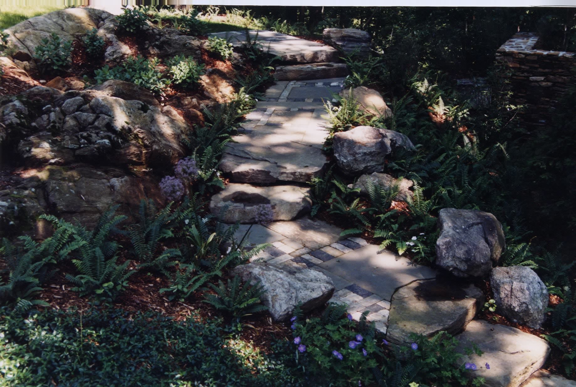 A stone walkway surrounded by rocks and plants