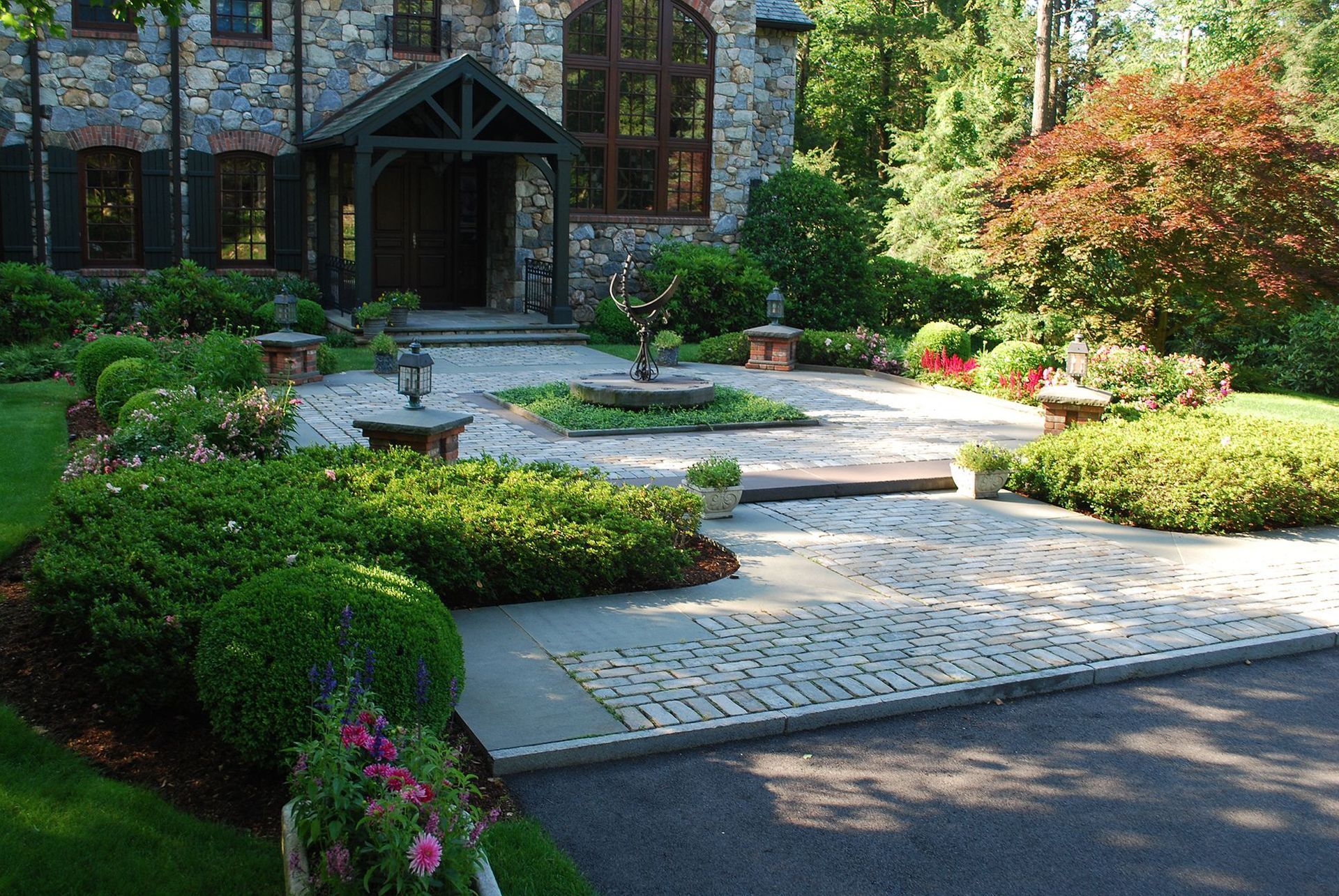 A large stone house with a driveway leading to it