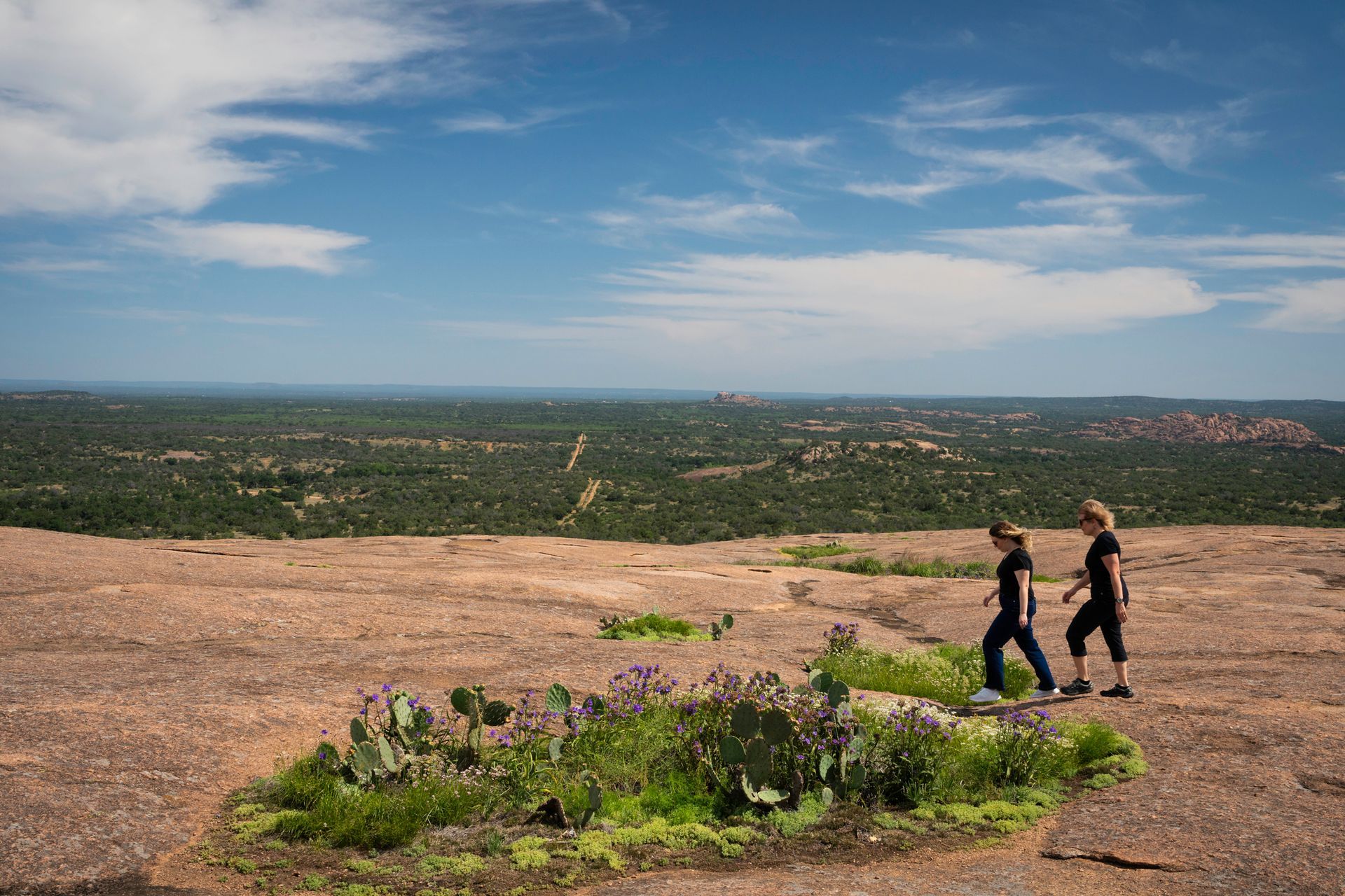 A person signs an insurance document held by another person at a table.