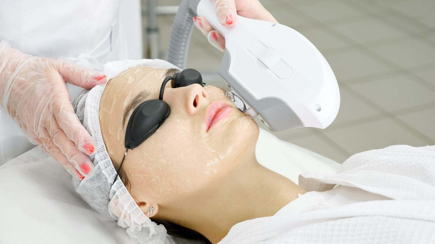 A woman is getting a laser treatment on her face.