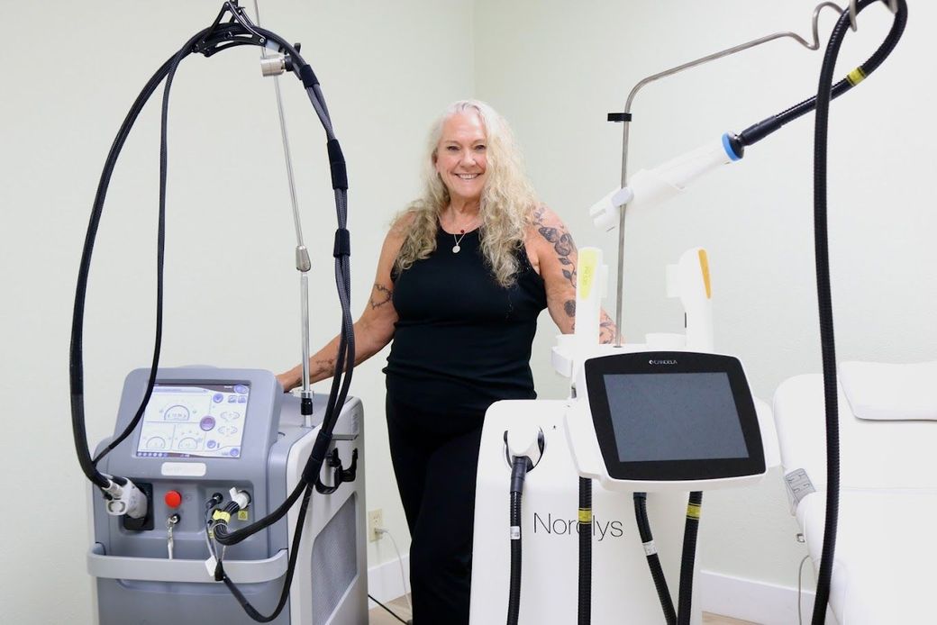 A woman is standing next to a machine in a room.