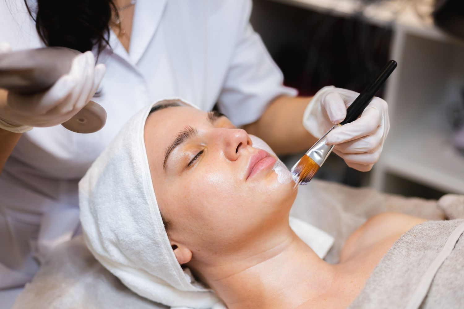 A woman is getting a facial treatment at a beauty salon.