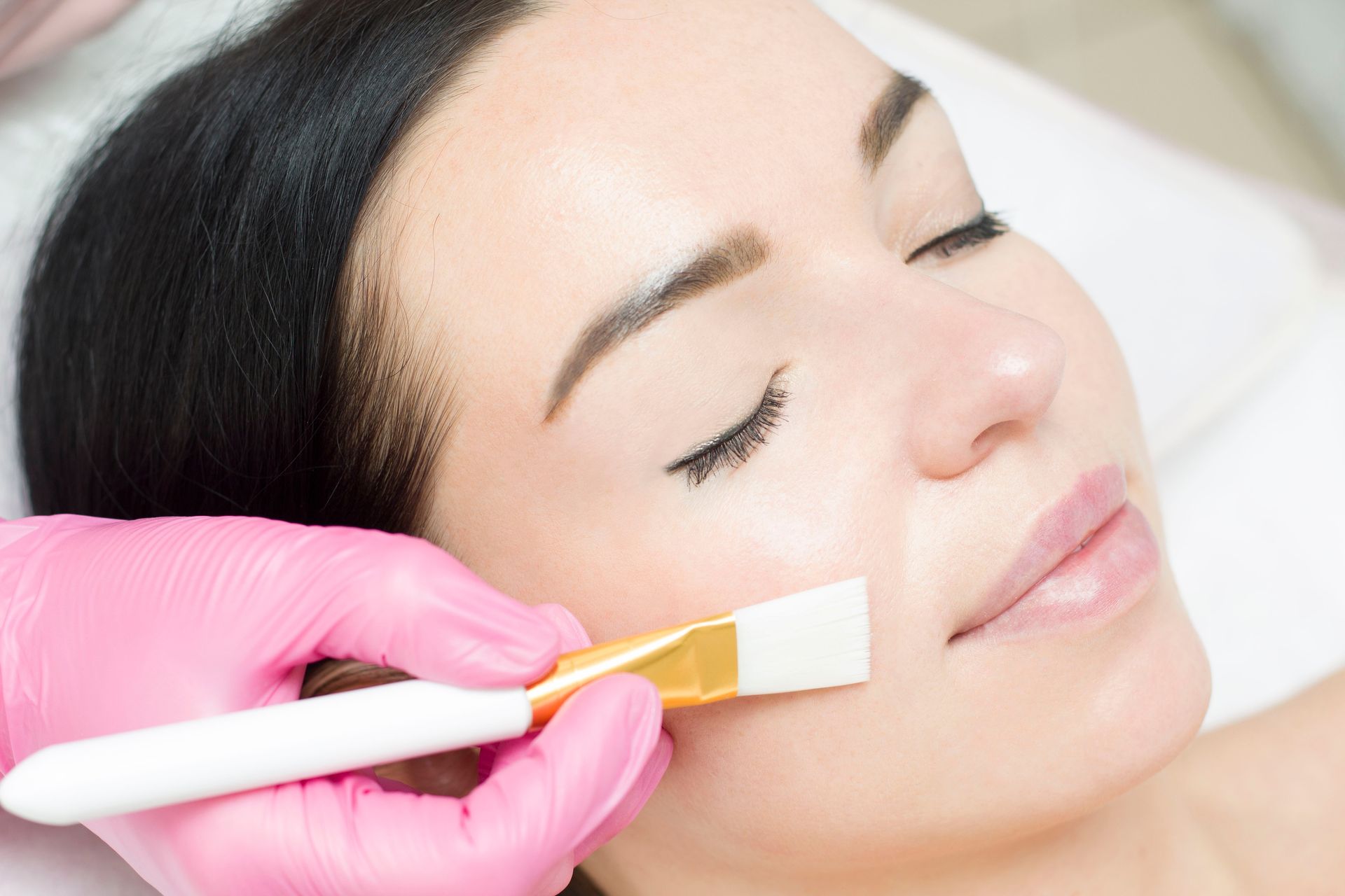 A woman is getting a facial treatment at a beauty salon.