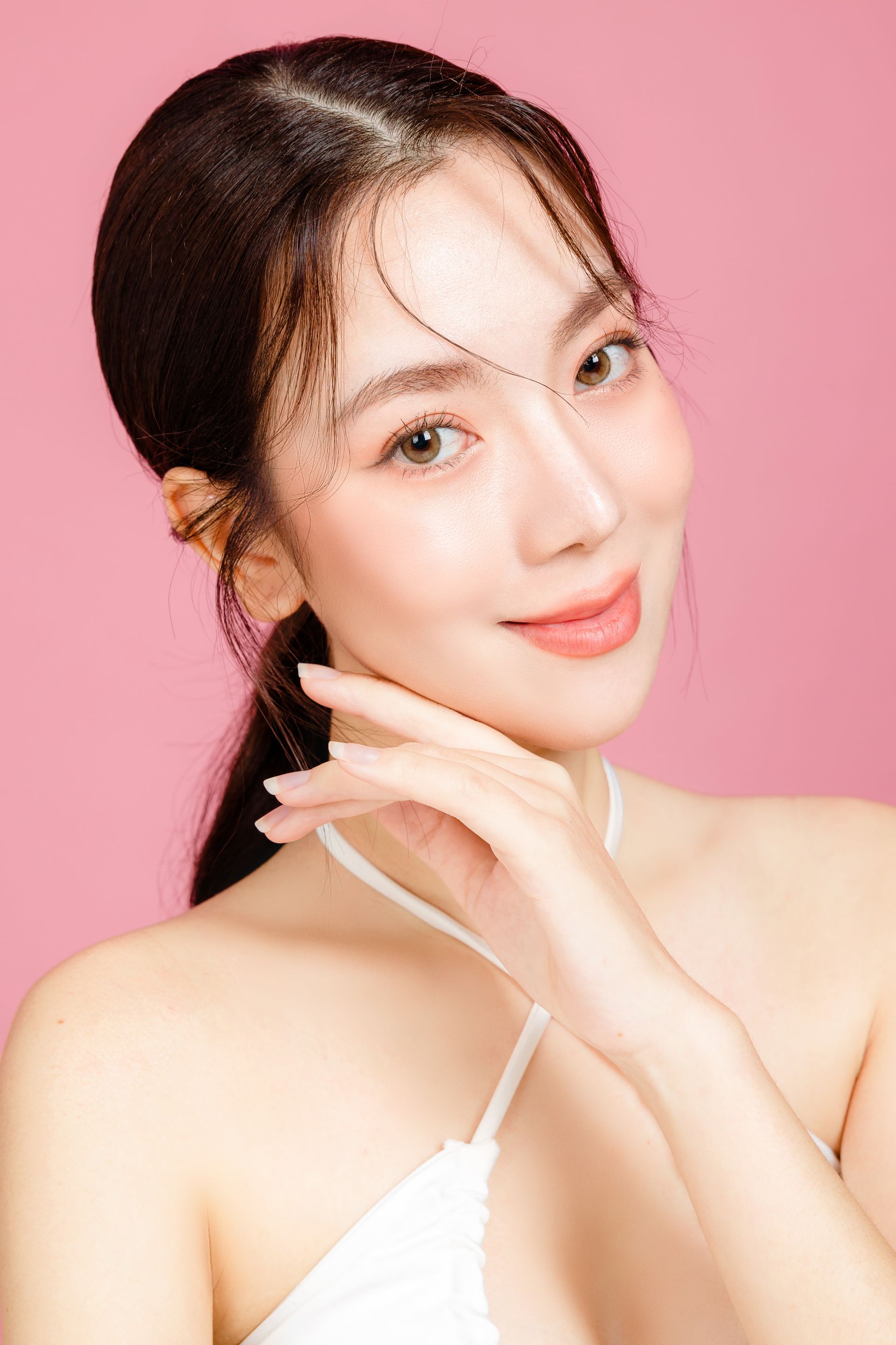 A close up of a woman 's face on a pink background.