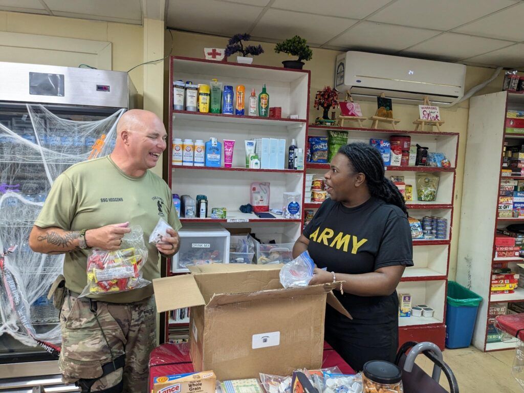 Two people in Army attire pack snacks in a store