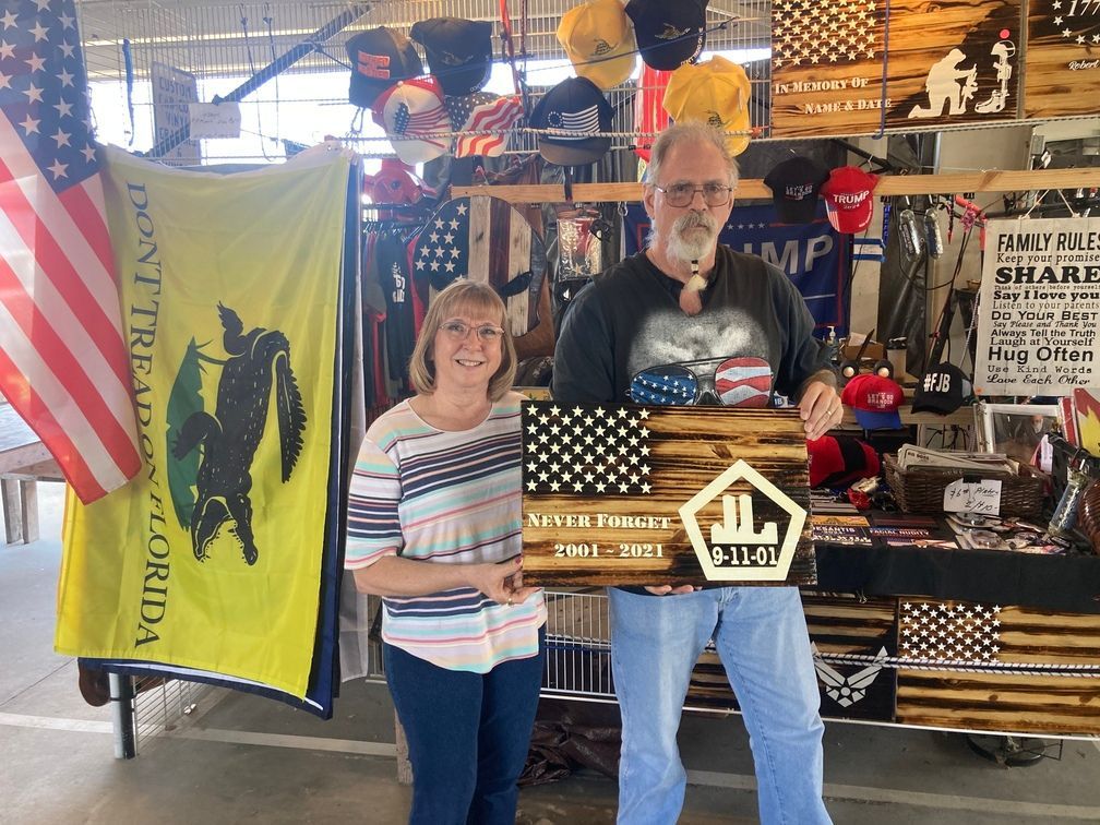 Man and woman hold wooden American flag